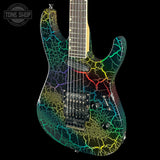 A six-string electric guitar with a black base and a vibrant, multicolor crackle pattern in green, yellow, blue, and red, shown against a solid black background with a Tone Shop logo in the top-left corner.