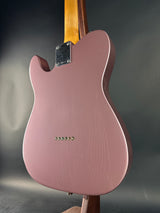 Pink electric guitar on a dark gray background