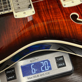 Used PRS SE Hollowbody II Piezo Orange Tiger on scale displaying weight.
