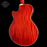 Close-up of the back of an electric guitar showing a vibrant red cherry wood grain finish, set against a solid black background with a Tone Shop watermark in the top left corner.