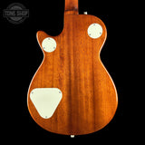 The back of a Fender electric guitar with a glossy brown wood finish, featuring cream-colored pickguard and mounting plates, shown against a solid black background.