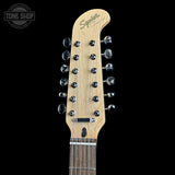 Close-up of the headstock of a 10-string electric guitar with a natural maple wood finish and black tuning pegs, shown against a solid black background. A Tone Shop watermark is visible in the top-left corner.