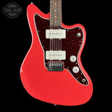 A red electric guitar with a double-cutaway body, white humbucker pickups, and a dark red glittery pickguard, shown against a solid black background. A Tone Shop watermark is visible in the top-left corner.