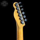 Close-up of the headstock of a Fender electric guitar with a natural maple wood finish and six silver tuning pegs, shown against a solid black background with a Tone Shop watermark in the top left corner.
