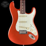 Red electric guitar with a white pickguard on a black background, featuring the Tone Shop logo.