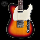 A classic Fender Telecaster electric guitar with a sunburst finish, featuring a cream pickguard and black control plate, shown against a solid black background with a Tone Shop watermark in the top left corner.