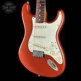 Red electric guitar with a white pickguard on a black background, featuring the Tone Shop logo.