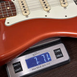 Guitar on a digital scale displaying weight