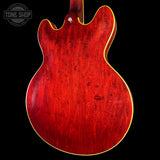 Red electric guitar body with a visible 'Tone Shop' logo.