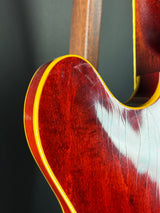 Close-up of a guitar's wooden neck and fretboard on a dark background