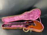 Electric guitar in a pink-lined case on a black background