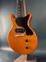 Close-up of a wooden electric guitar on a reflective surface