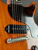 Close-up of a guitar's neck and headstock with a focus on the tuning pegs.