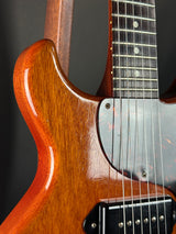 Close-up of a guitar's neck and body on a dark background