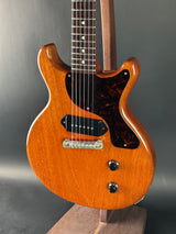 Close-up of a wooden electric guitar on a gray surface