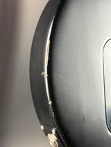 Close-up of a black car bumper with visible damage