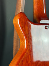 Close-up of a guitar's wooden body with a dark gray background