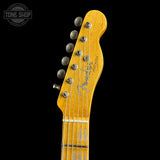 Close-up of the headstock of a Fender Telecaster electric guitar in a natural maple finish, showing the brand logo and tuning pegs against a solid black background.