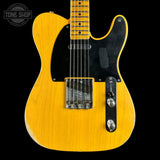 A classic Fender Telecaster electric guitar in a natural yellow finish, featuring a black pickguard and chrome hardware, shown against a solid black background with a Tone Shop watermark in the top left corner.