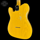 The back of a yellow-finish Fender Telecaster electric guitar, showing the wood grain, hardware, and a distressed finish, set against a solid black background with a Tone Shop watermark.