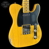 A classic Fender Telecaster electric guitar in a distressed yellow finish, featuring a black pickguard and chrome hardware, shown against a solid black background with a Tone Shop watermark in the top left corner.