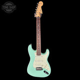 Electric guitar with a light green body and brown neck on a black background, featuring 'Tone Shop' logo.