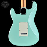 Turquoise electric guitar with a visible brand logo in the corner.