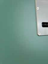 Close-up of a metallic surface with a small rectangular cutout and screws.