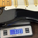 Used 1988 MIJ Squier Black on scale displaying weight.