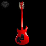 A red electric guitar shown from the back against a solid black background, with a Tone Shop watermark in the upper left corner.