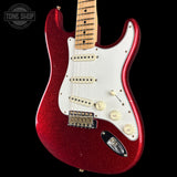 A red glitter electric guitar with a white pickguard and maple neck, shown against a solid black background. A Tone Shop watermark is visible in the top left corner.