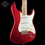 A red glitter electric guitar with a white pickguard and maple neck, shown against a solid black background with a Tone Shop watermark in the top left corner.