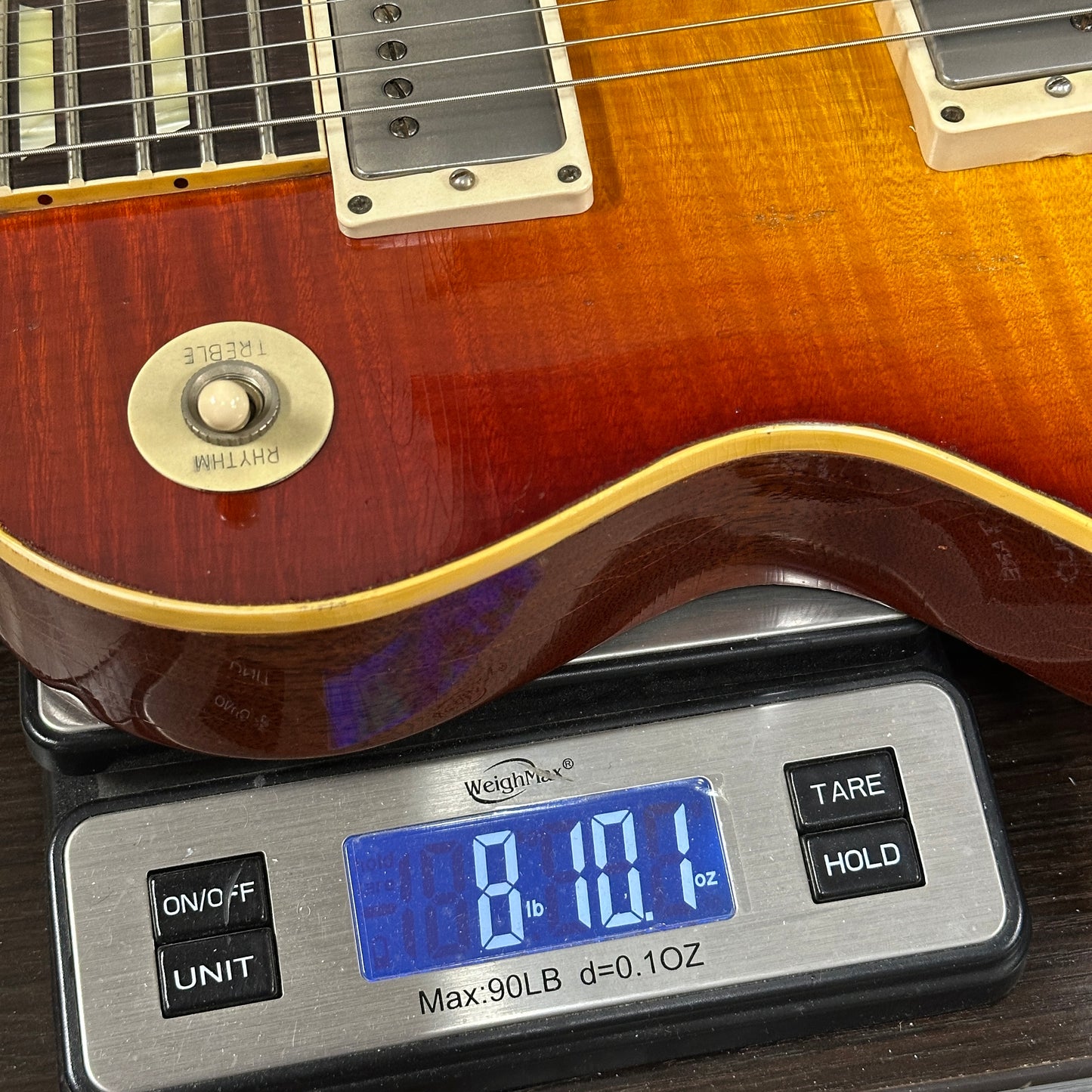 Electric guitar on a digital scale displaying weight