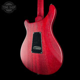 Red electric guitar body with a visible brand logo on a black background