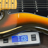 Vintage 1979 Fender Stratocaster Hardtail Sunburst w/non-original case on scale displaying weight.