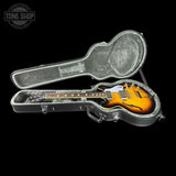 Guitar in a hard case with 'Tone Shop' logo in the corner
