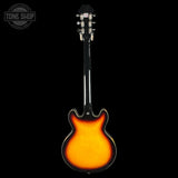 Electric guitar with sunburst finish on a black background, featuring the Tone Shop logo.