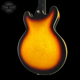 Guitar body with a sunburst finish on a black background, featuring the Tone Shop logo.