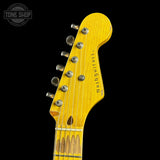 Close-up of a yellow guitar headstock with 'Tone Shop' logo in the corner.