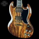 A double-cutaway electric guitar with a rich, glossy natural wood grain finish, black pickguard, and gold hardware, shown against a solid black background.