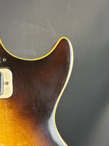Close-up of a guitar's back with a dark brown and orange gradient on a gray background
