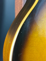 Close-up of a guitar's soundhole with a dark brown and gold finish.