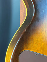 Close-up of a guitar's wood finish with a dark and light brown gradient.