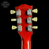 Close-up of a red guitar headstock with tuning pegs on a black background, featuring 'Tone Shop' branding.