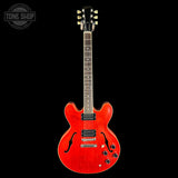 Red electric guitar on a black background with 'Tone Shop' logo.