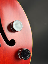 Close-up of a guitar with two control knobs on a dark background