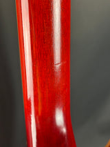 Close-up of a red wooden object with a white stripe on a dark background