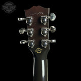 Close-up of the headstock of a Gibson L-0004 electric guitar against a solid black background, showing the dark brown wood, silver tuning pegs, and gold Gibson logo.
