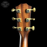 Guitar headstock with tuning pegs on a black background, featuring the Taylor brand.