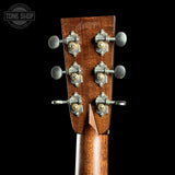 Close-up of a guitar headstock with tuning pegs on a black background, featuring the Tone Shop logo.